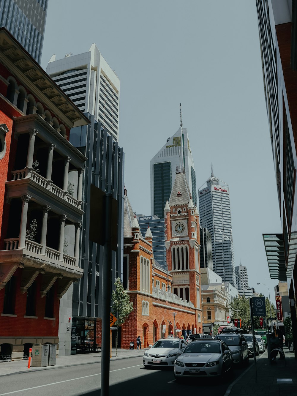 a city street lined with tall buildings and a clock tower