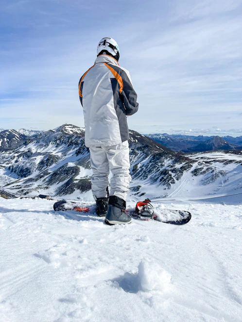 a man standing on top of a snow covered slope