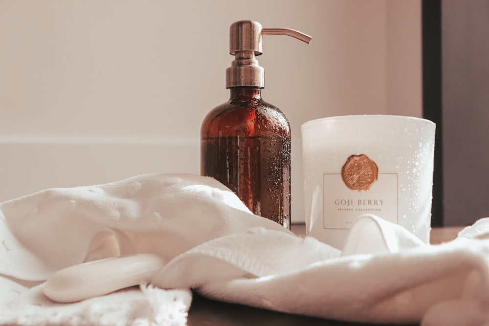 a close up of a bottle of soap and a towel on a table