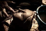 An artisan carefully applying colorful clay to a canvas.