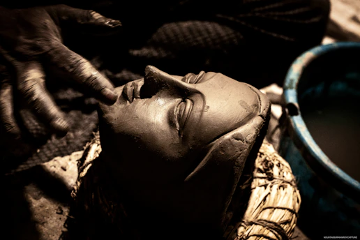 An advanced ceramic artist carefully carving intricate details on a clay sculpture.