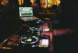 DJ booth with country music playlist projected on screen.