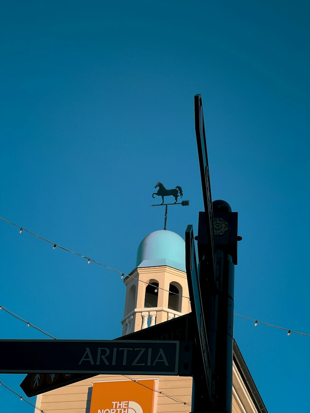 a street sign and a building with a clock tower in the background