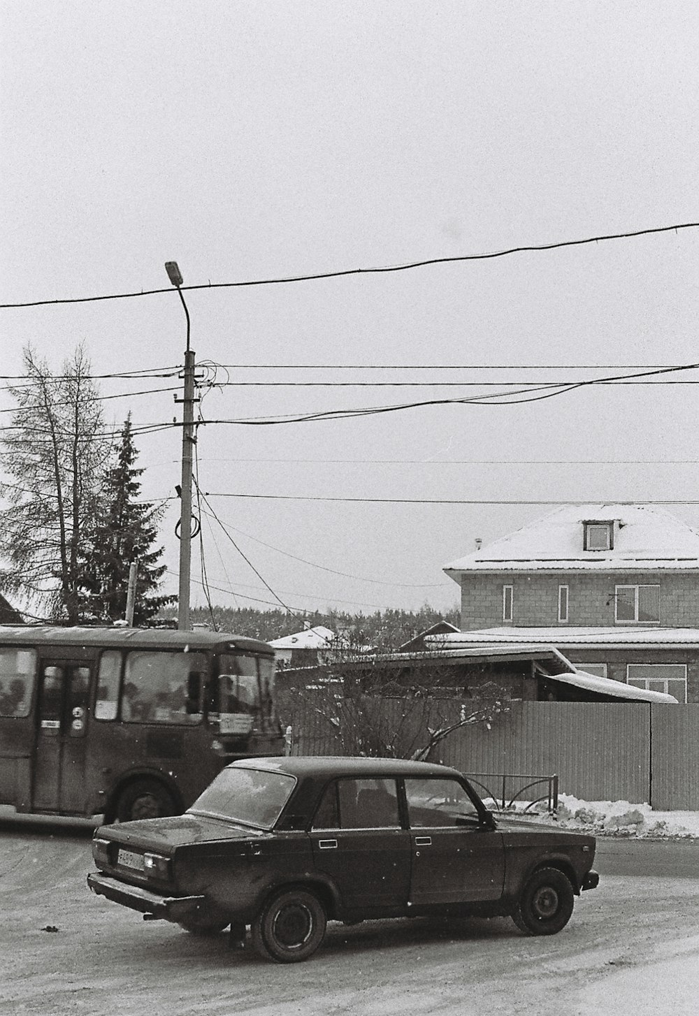 a black and white photo of a car and a bus