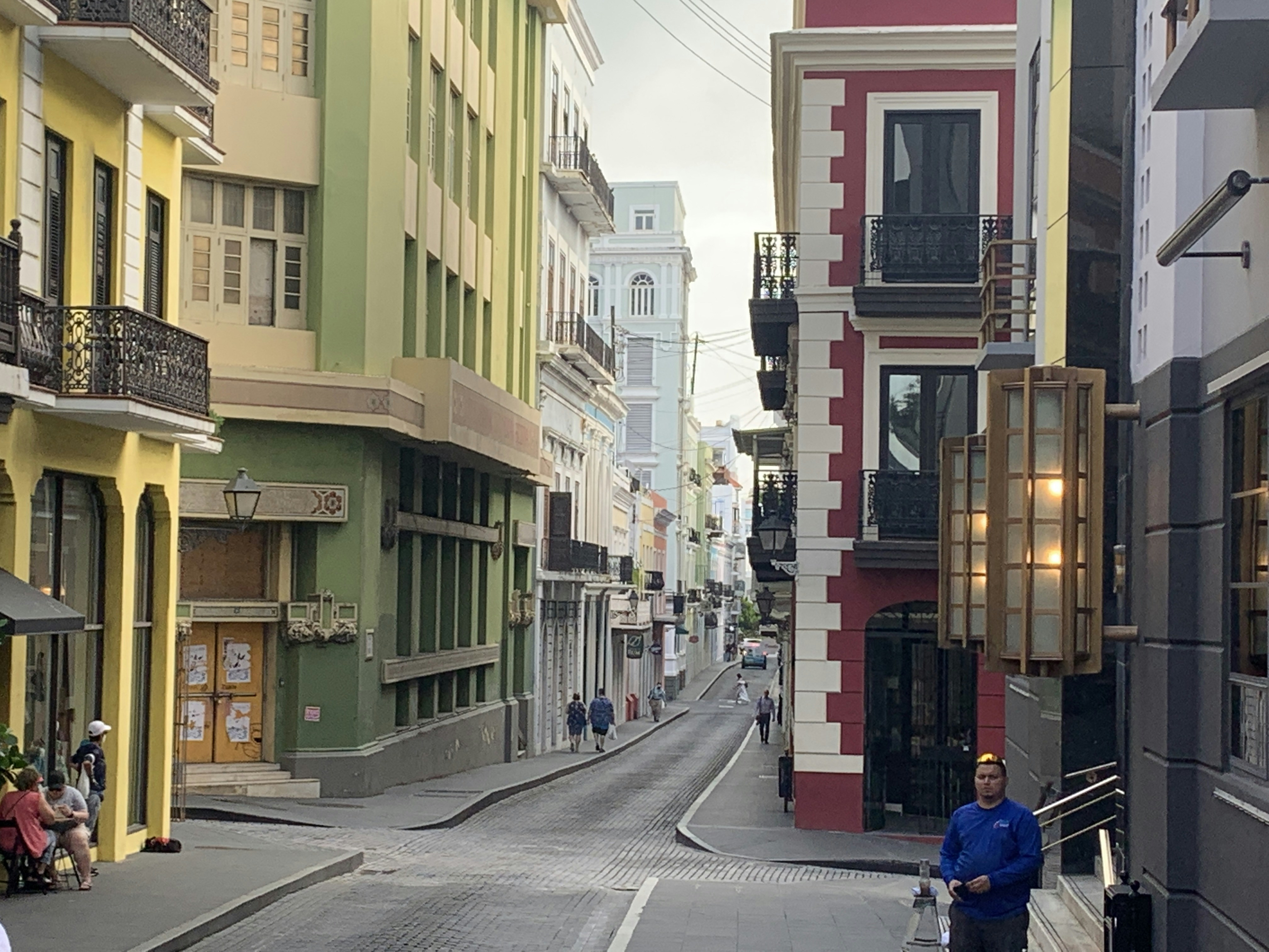 a man walking down a street next to tall buildings