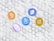 Five cryptocurrency symbols are depicted as coins with distinct logos floating above a pattern of white 3D cubes. The coins represent Bitcoin, Ethereum, Tezos, Polygon, and Binance Coin.