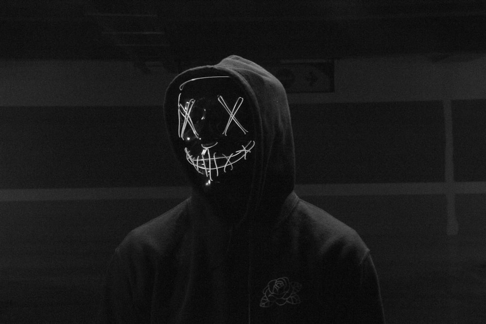 a person wearing a mask in a dark room