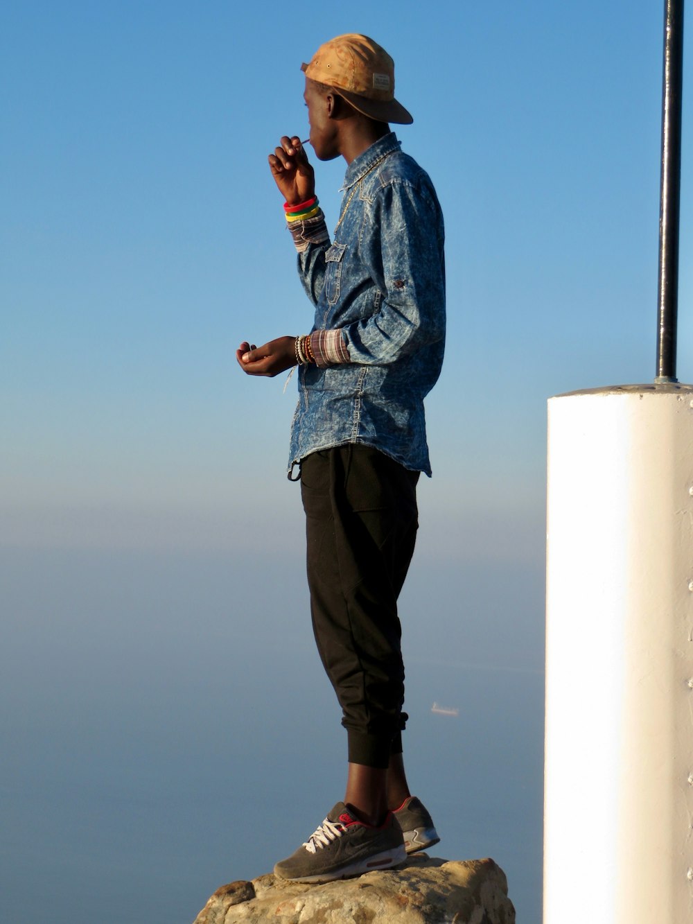 a man standing on top of a rock near the ocean