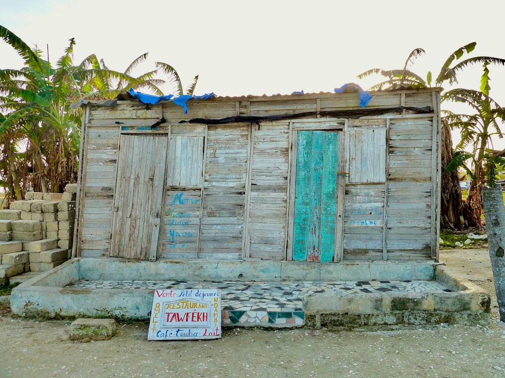 a wooden shack with a sign in front of it