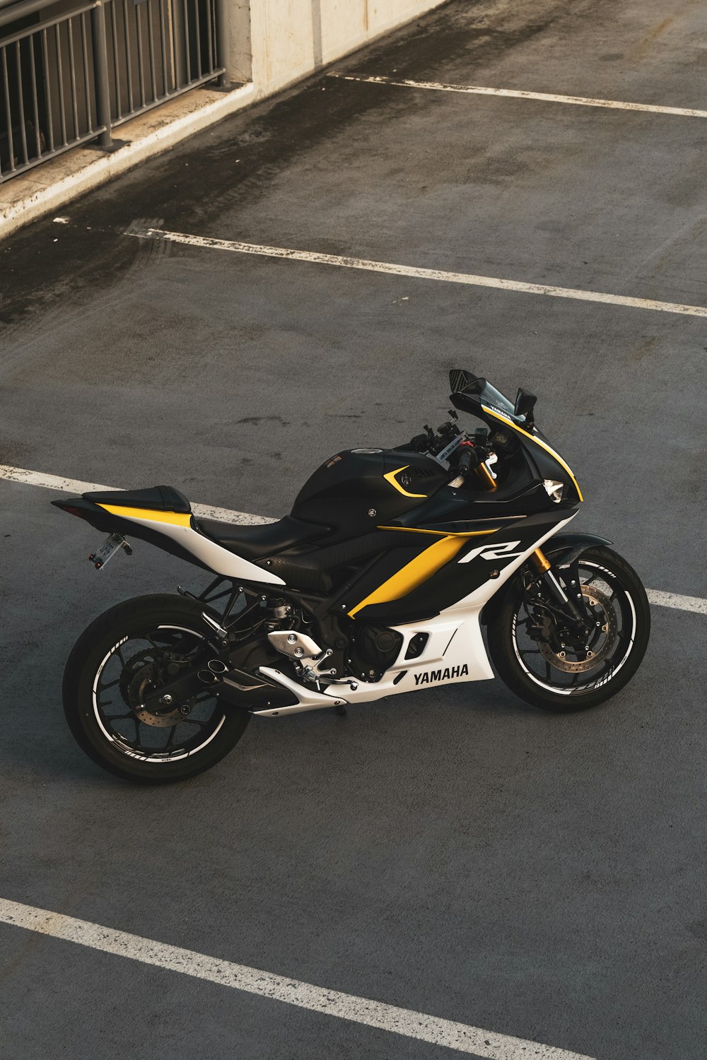 a black and yellow motorcycle parked in a parking lot