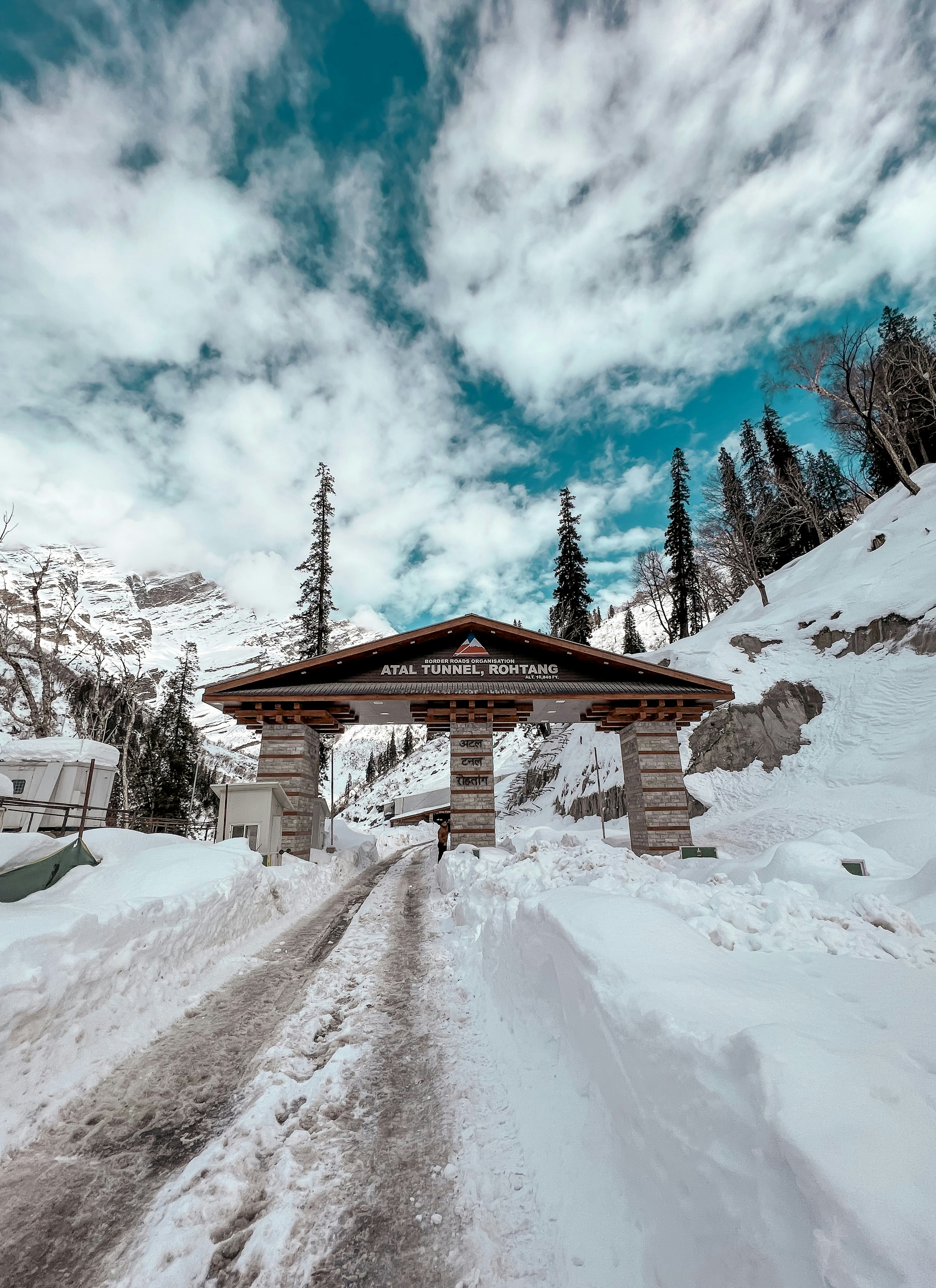 a snow covered road with a sign on the side of it