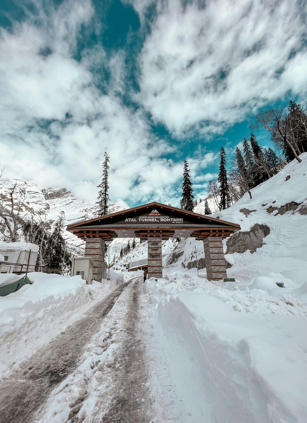 a snow covered road with a sign on the side of it