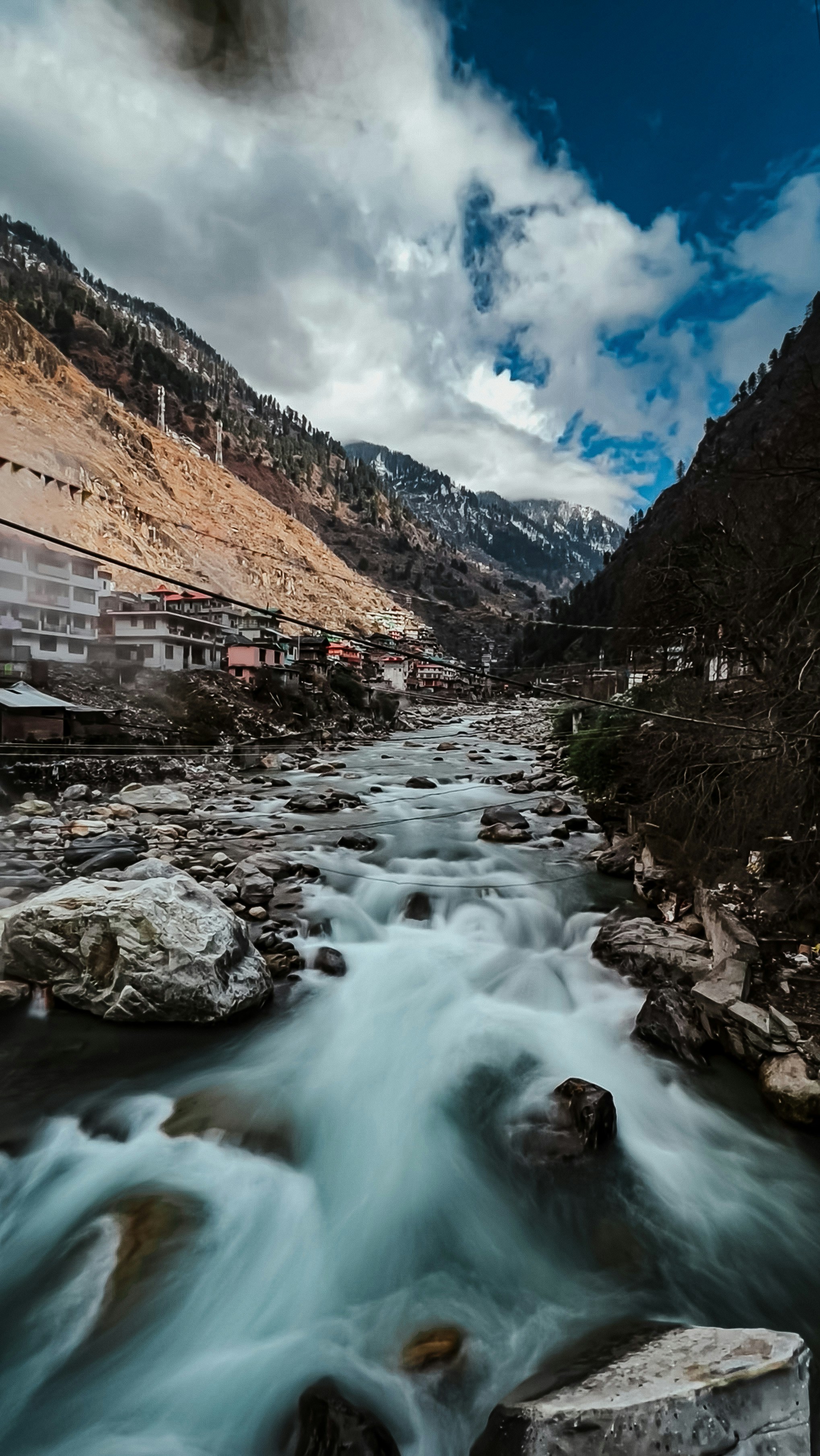 a river running through a valley surrounded by mountains