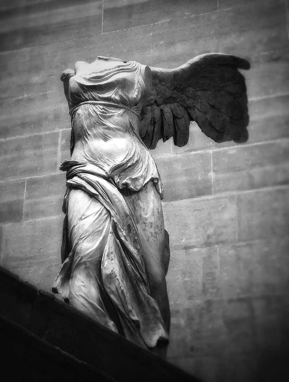a black and white photo of a statue of an angel