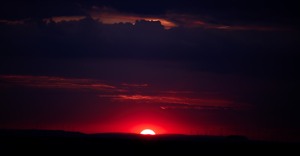 the sun is setting in the sky over a field