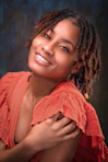 a woman with dreadlocks is smiling at the camera