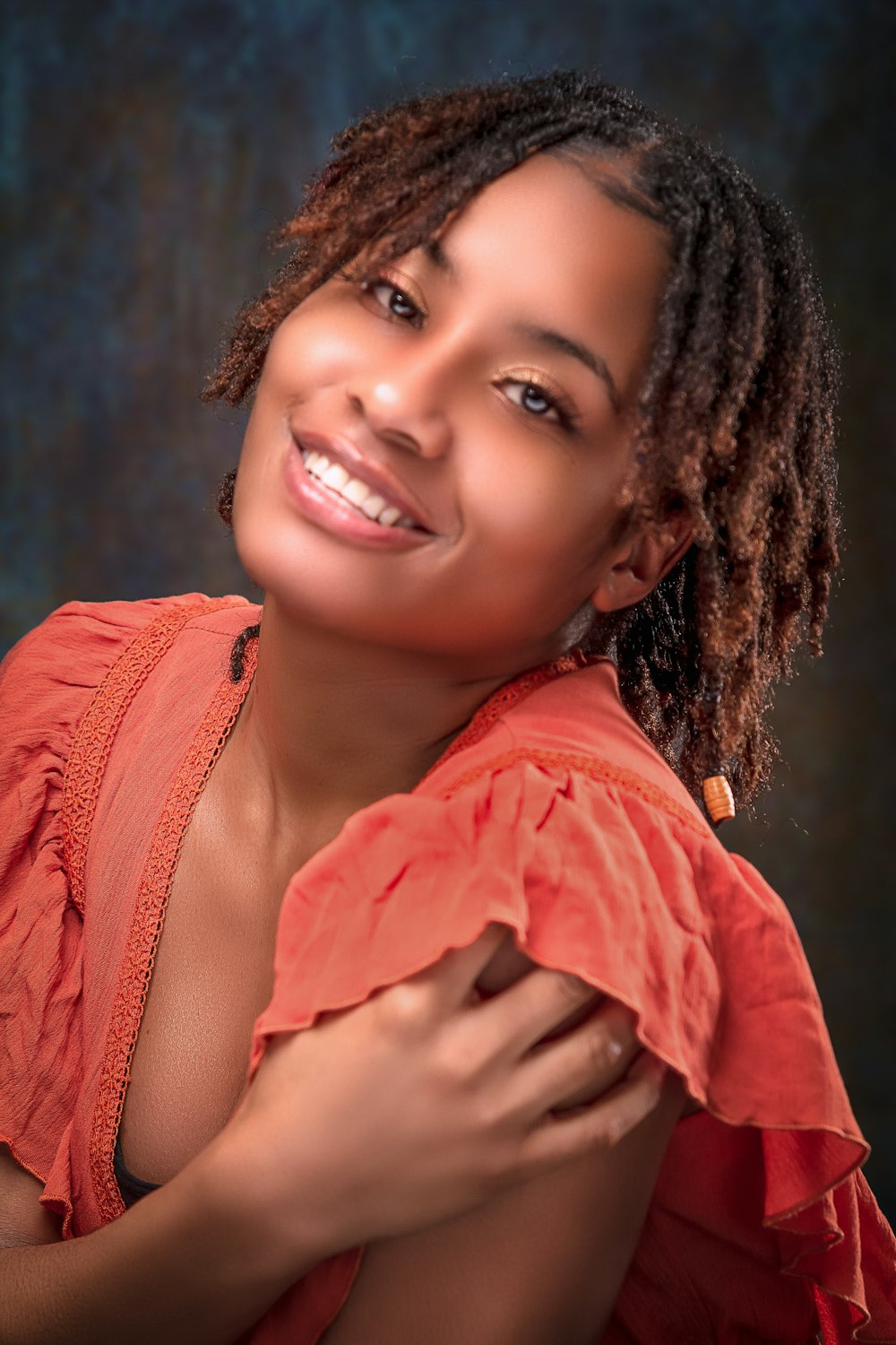 a woman with dreadlocks is smiling at the camera