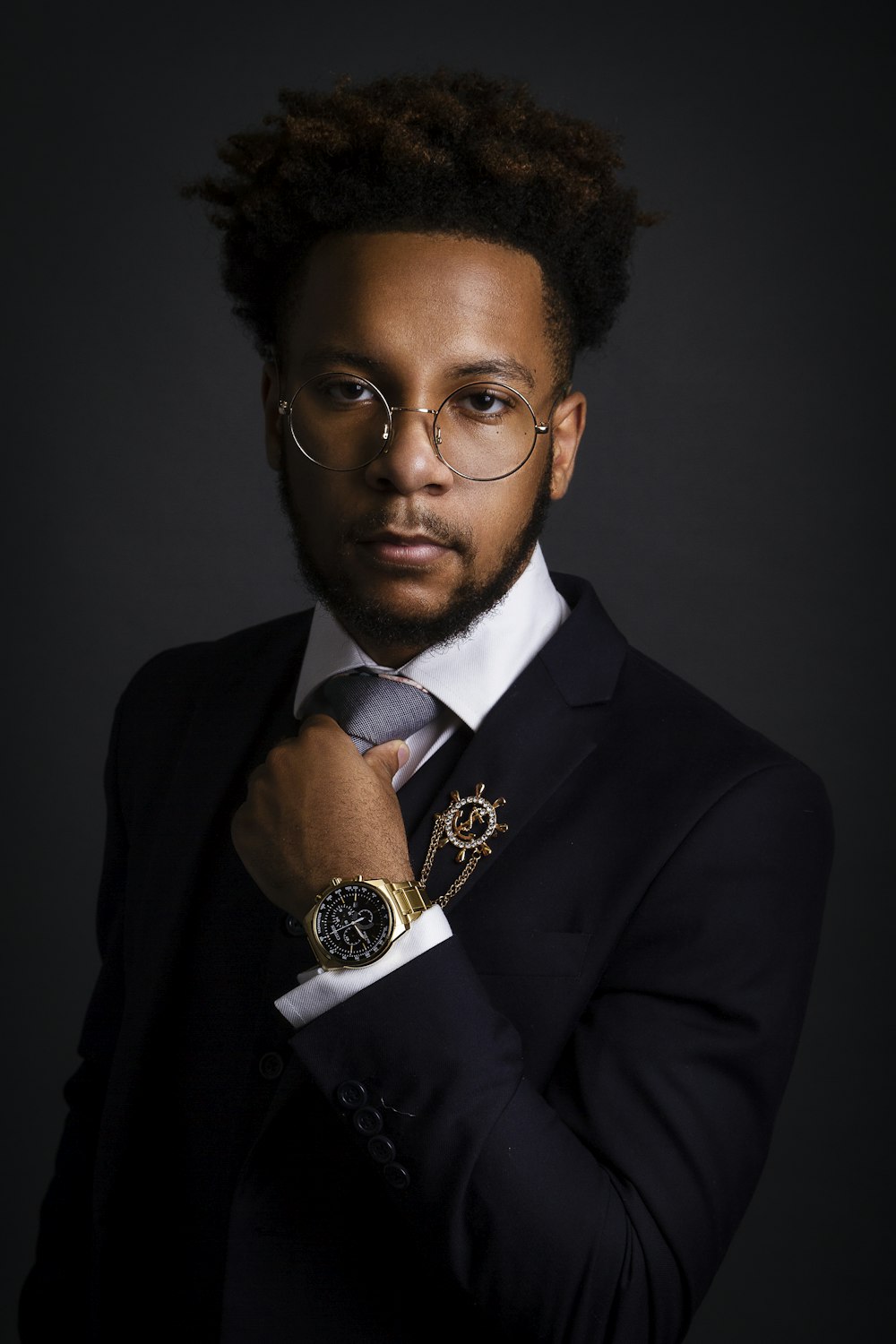 a man in a suit and tie with a watch on his wrist