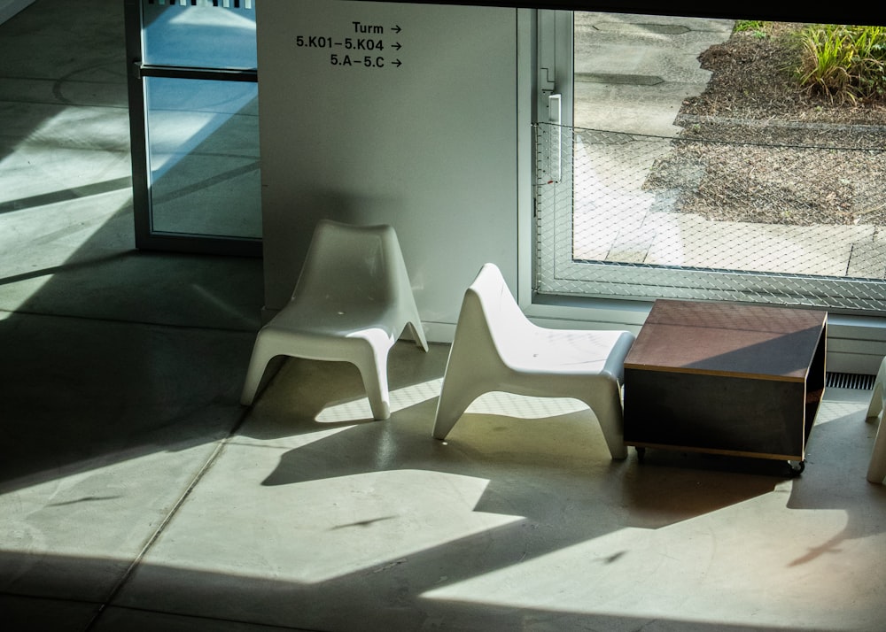 a couple of white chairs sitting next to a window