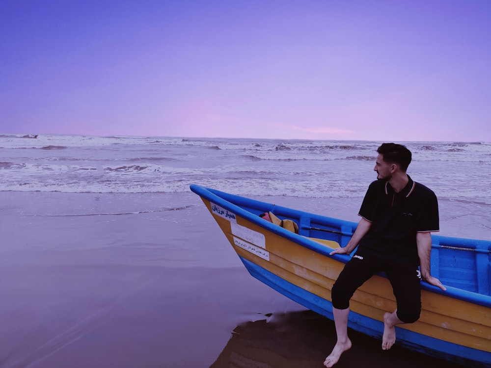 a man sitting on a boat on the beach