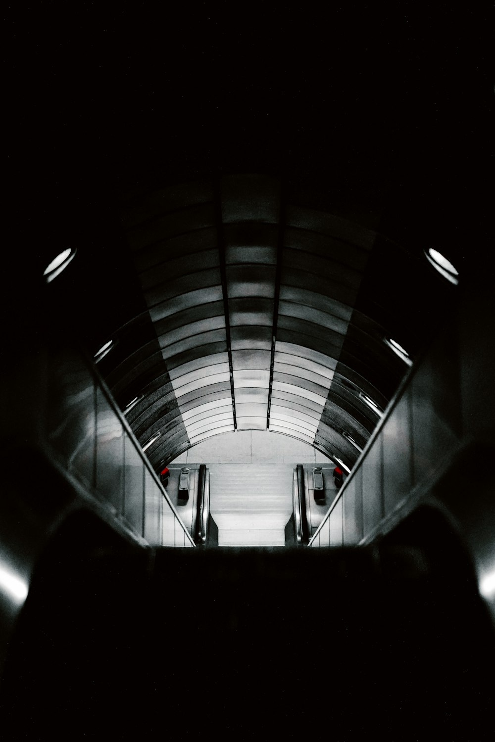 a black and white photo of an escalator