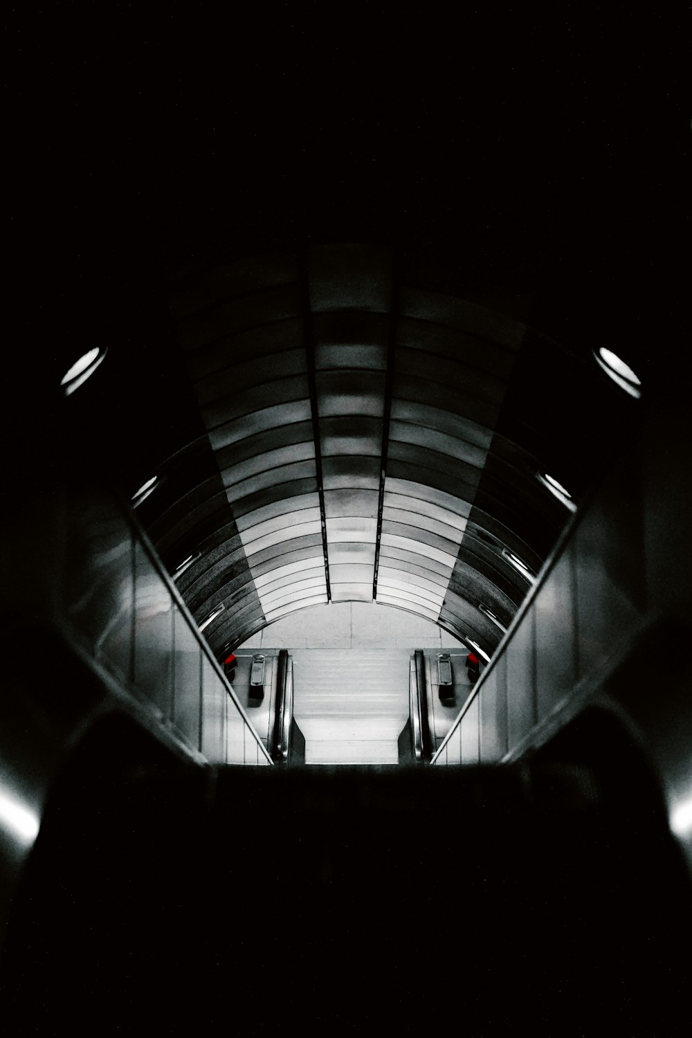 une photo en noir et blanc d’un escalier mécanique