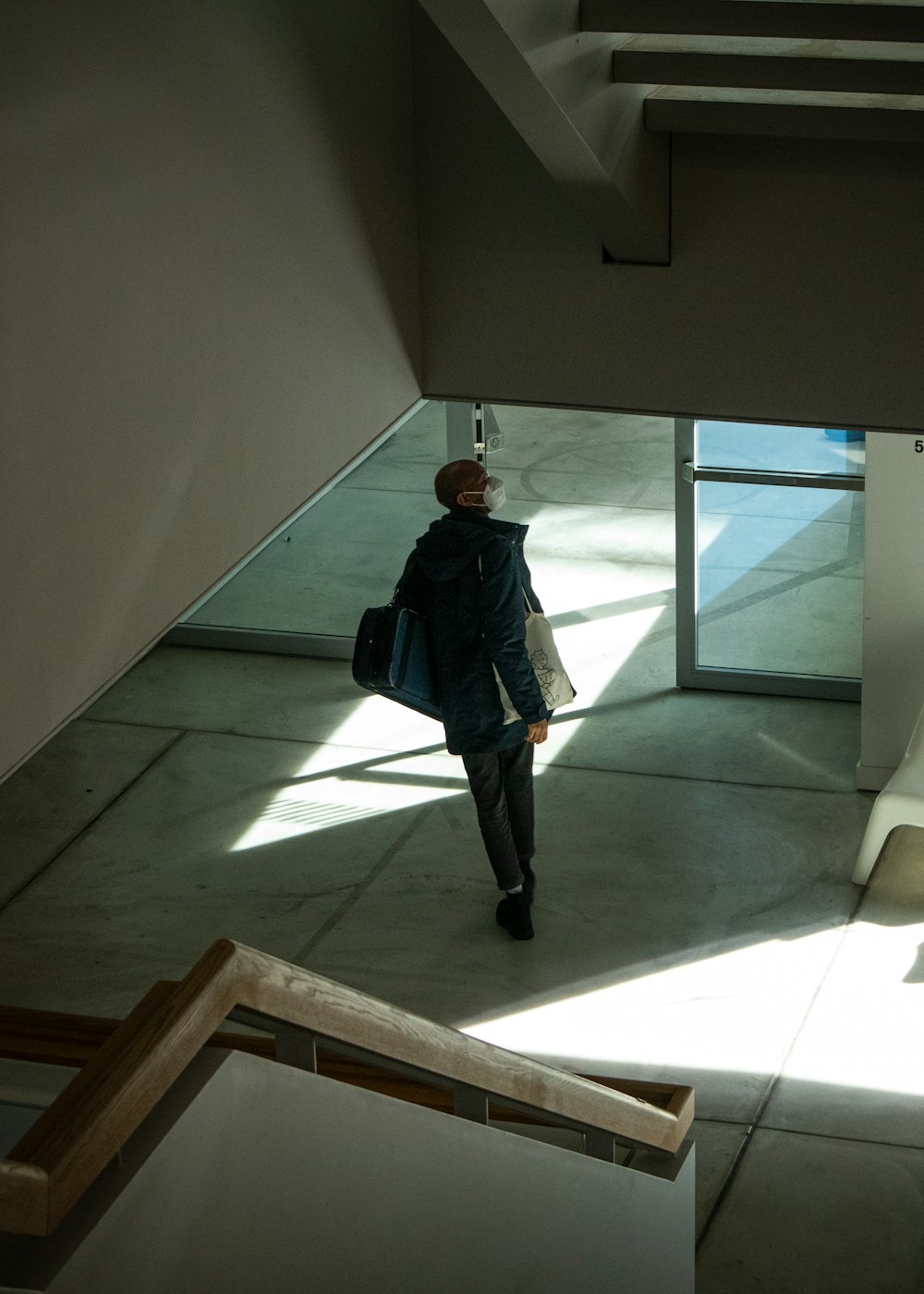 a woman walking down a hallway in a building