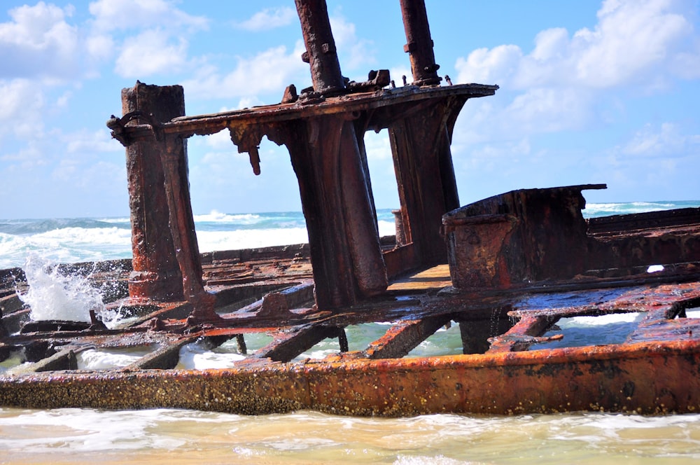 a rusted out ship sitting on top of a beach