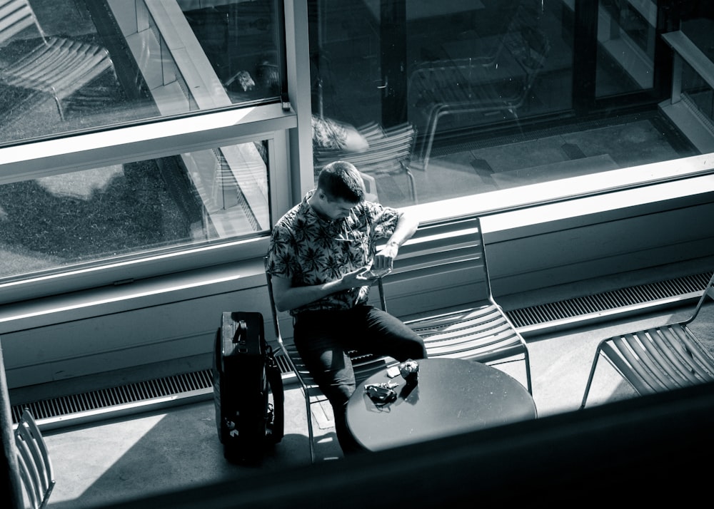 a man sitting at a table in front of a window