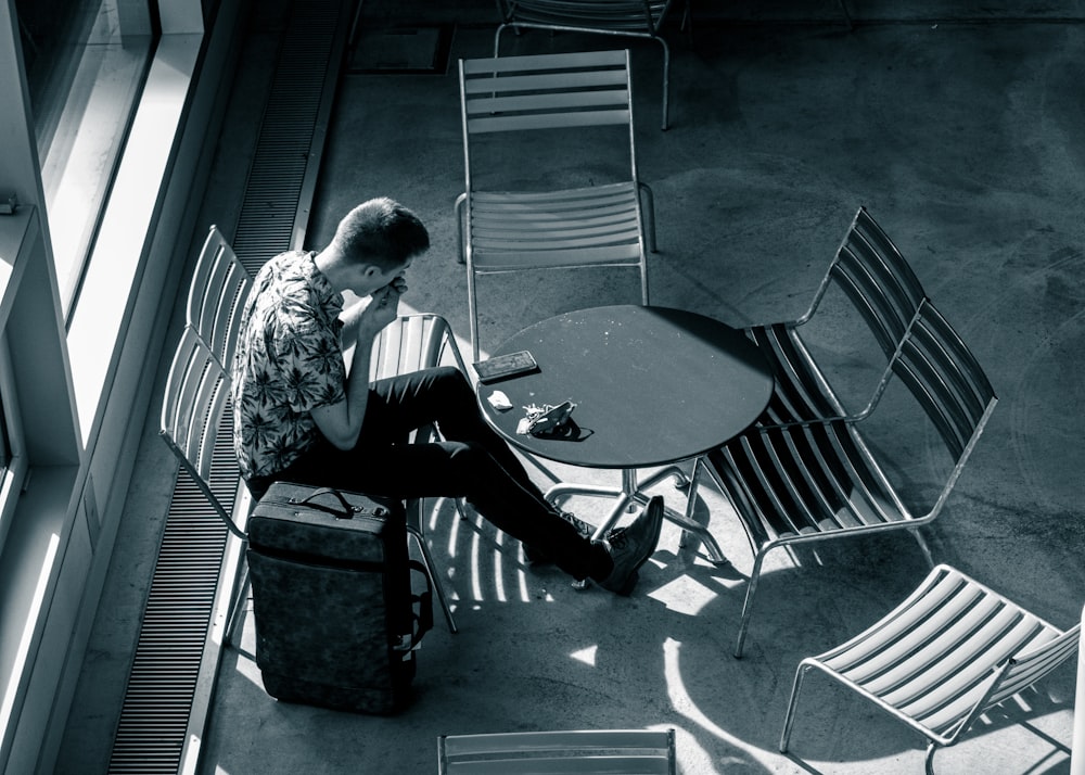 a man sitting at a table with a suit case