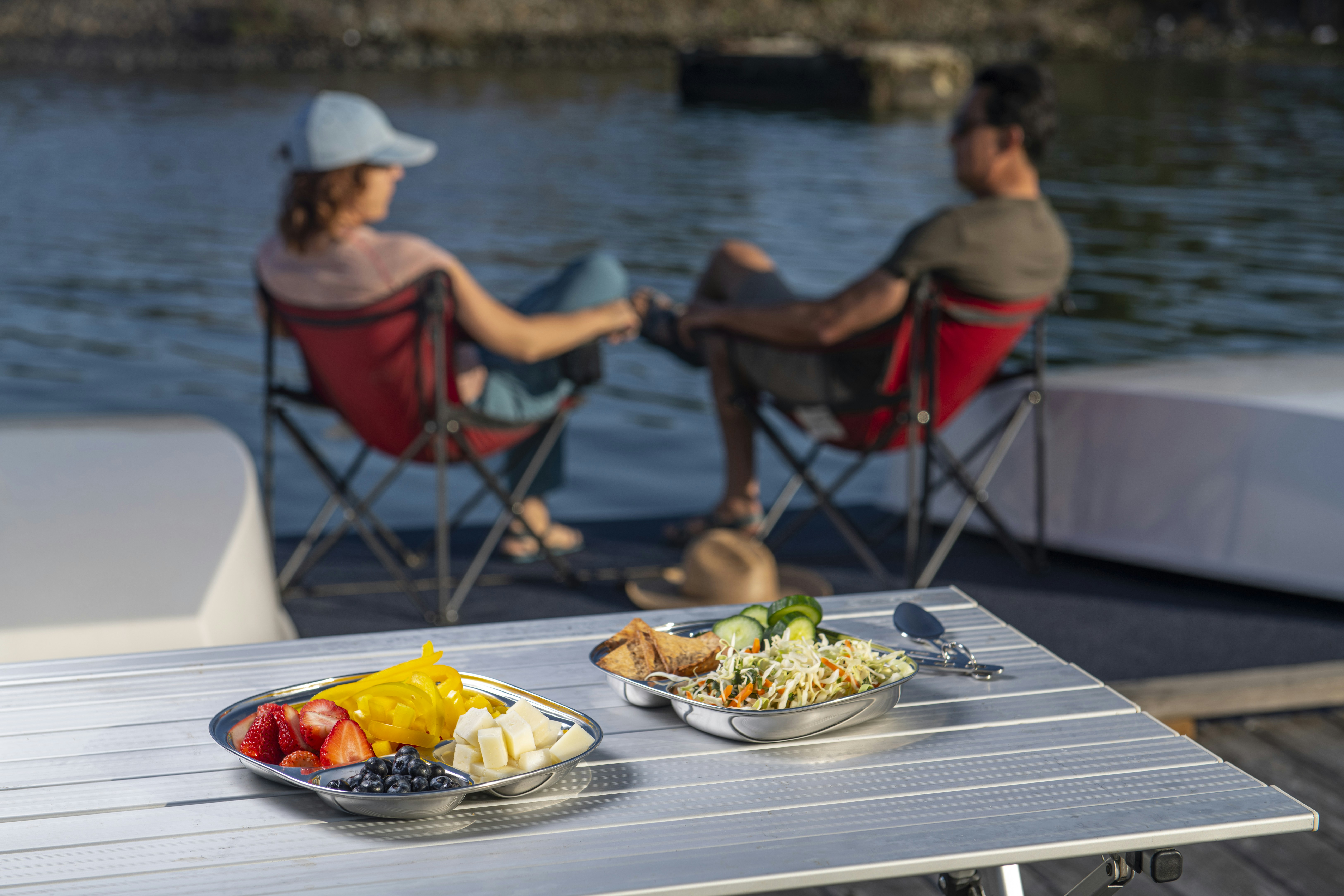 a couple of people sitting at a table with plates of food