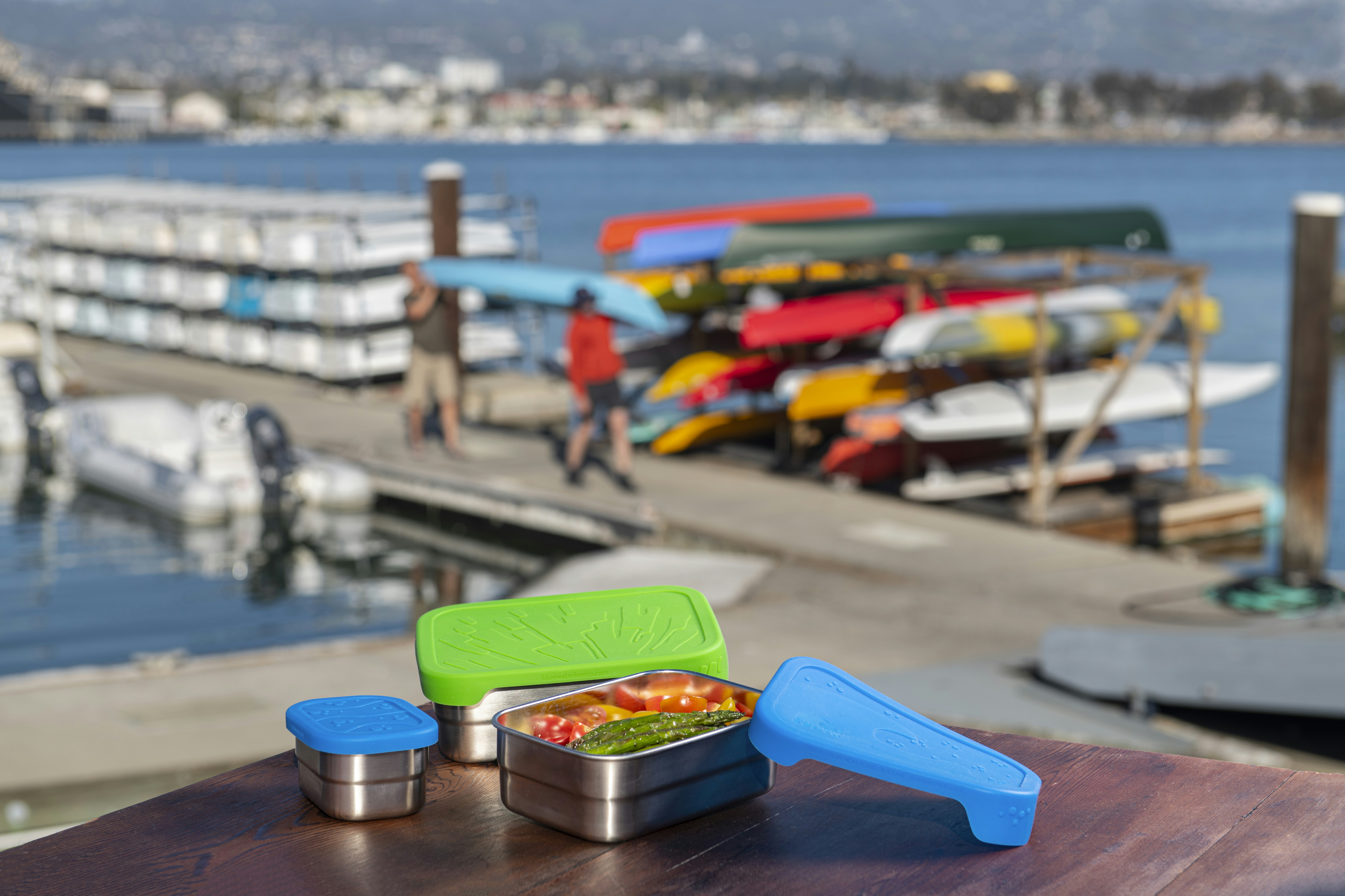 a couple of containers of food sitting on top of a wooden table