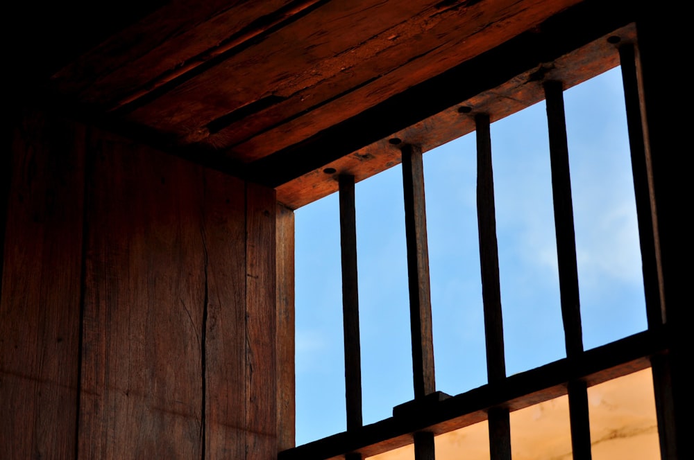 a window with bars and a sky in the background