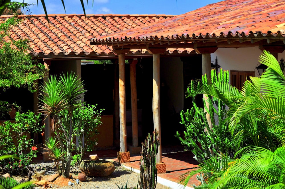 a house with a red tiled roof surrounded by greenery