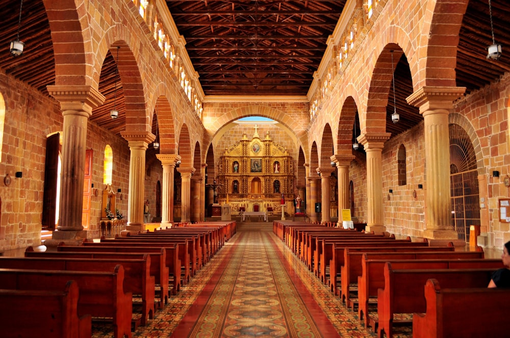 the inside of a church with pews and arches