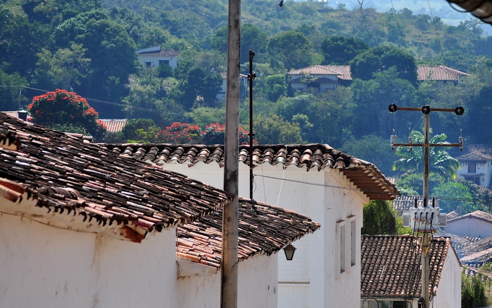 une vue d’une rue avec des maisons et des collines en arrière-plan