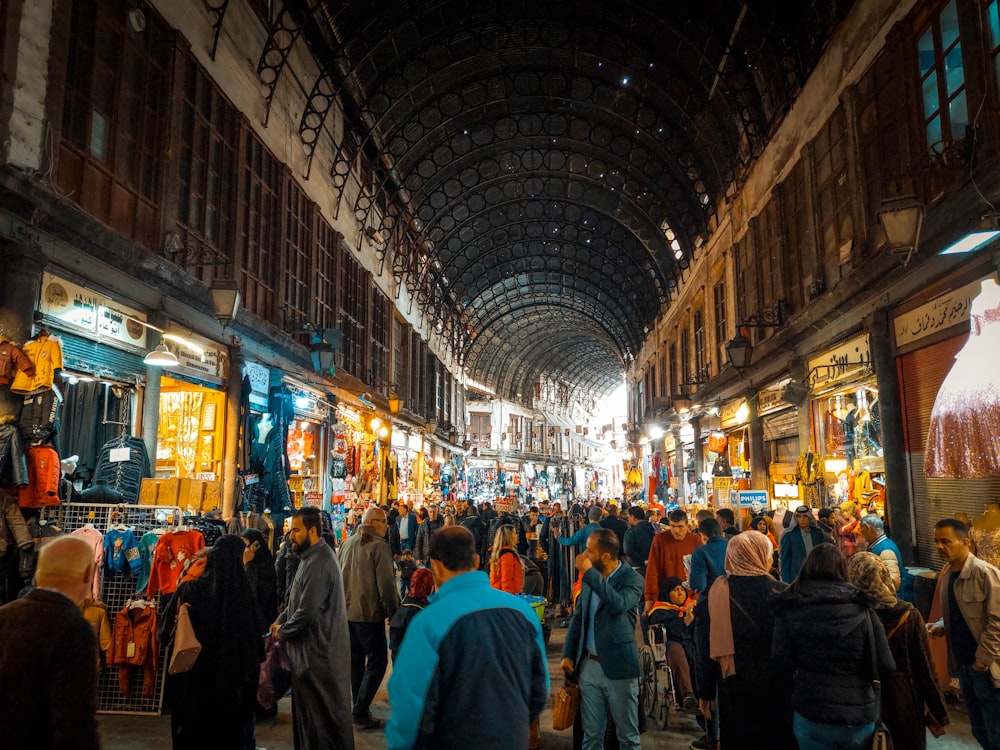 a large group of people walking through a market