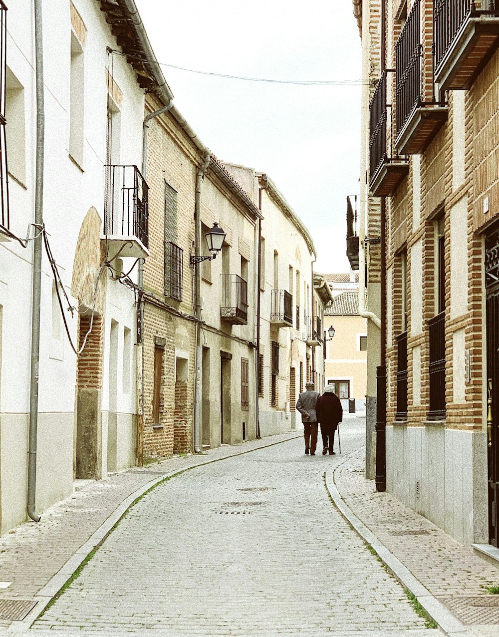 a couple of people walking down a street