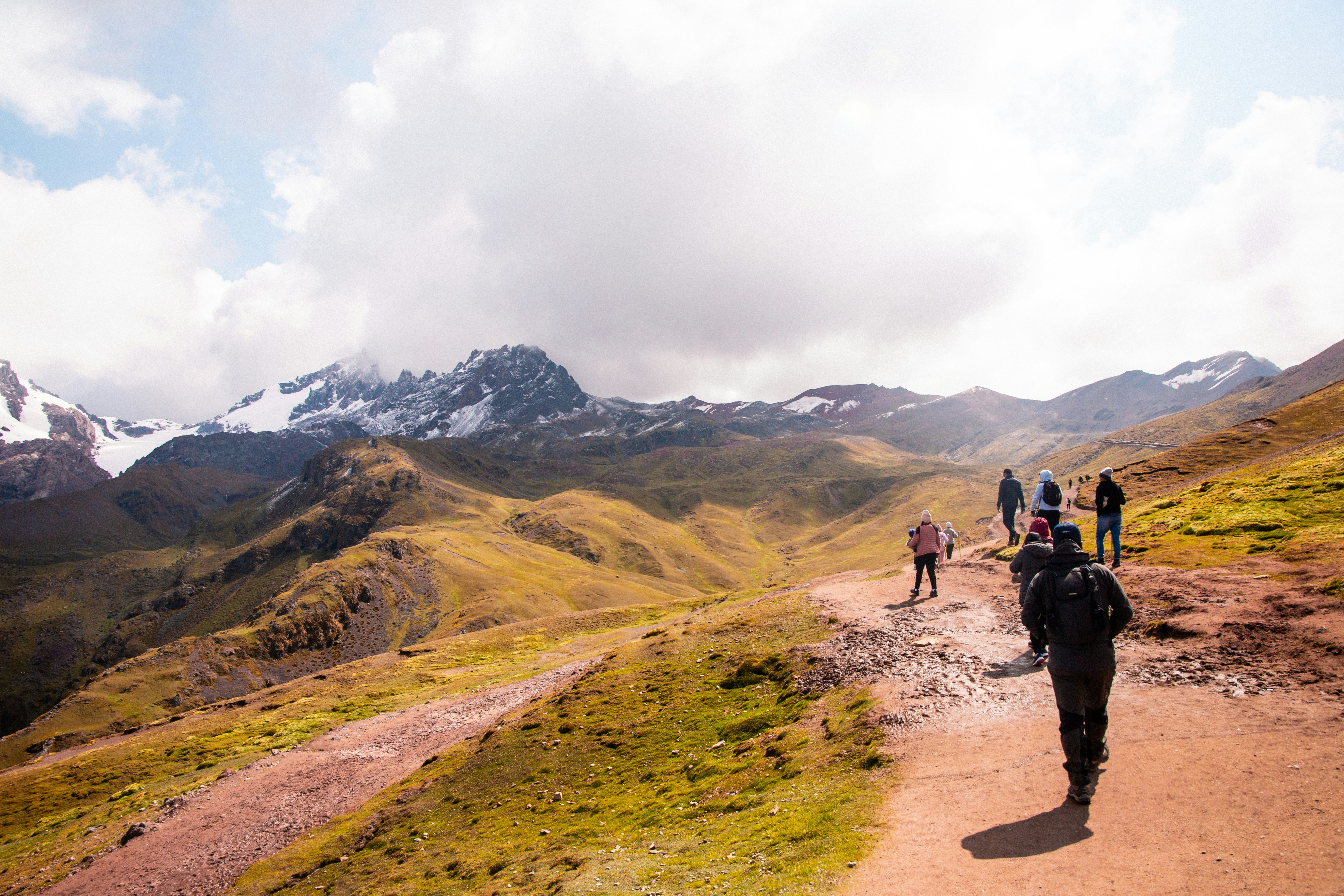 a group of people walking up a dirt road, 