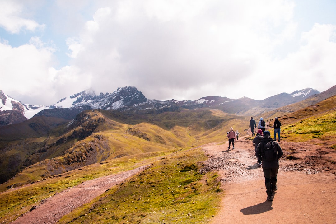 a group of people walking up a dirt road,