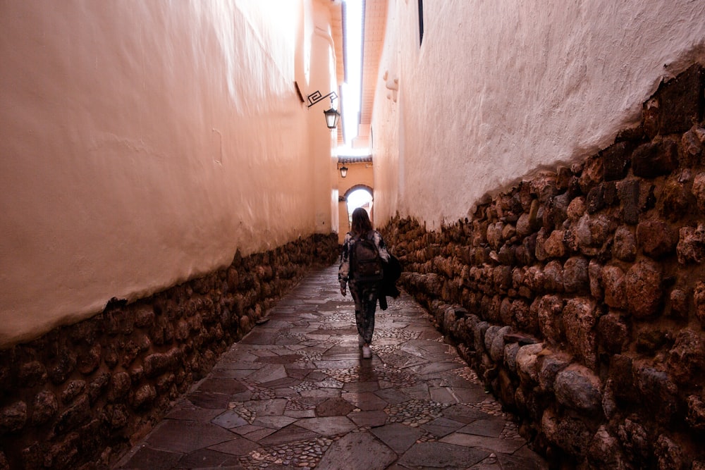 Una mujer caminando por un callejón estrecho