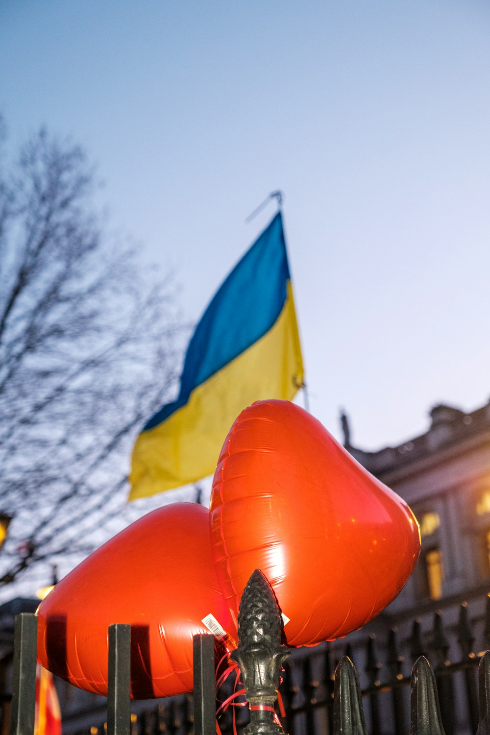 a large red balloon sitting on top of a metal fence