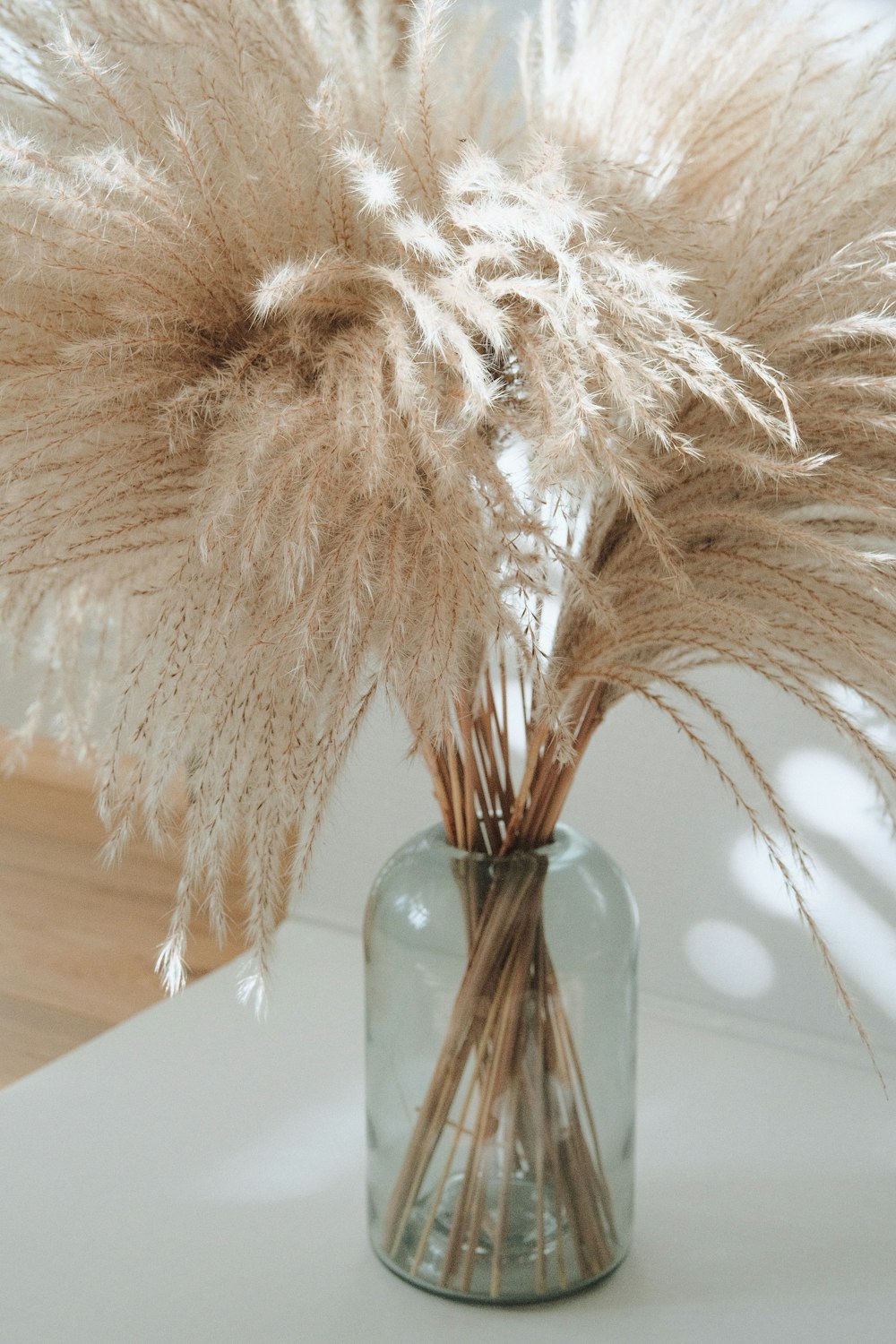 a vase filled with dried grass on top of a table