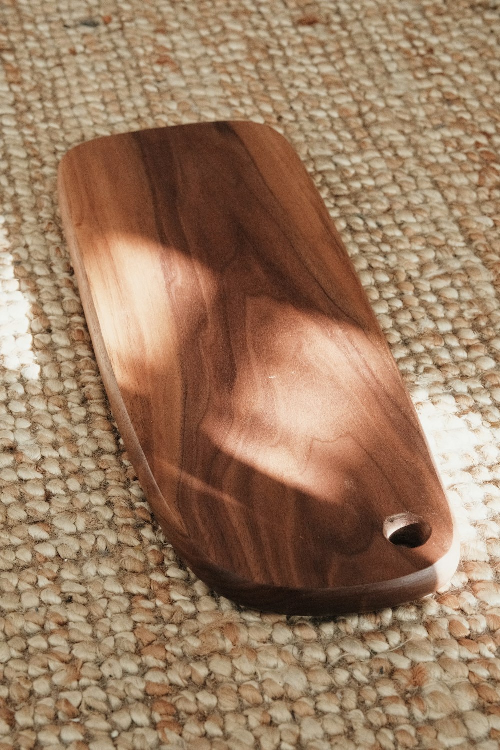 a wooden object laying on top of a rug