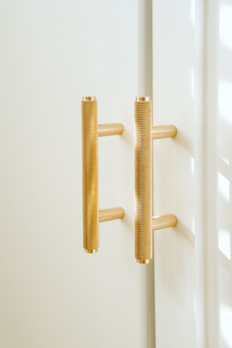 Various cabinet hardware options displayed on painted cabinet samples