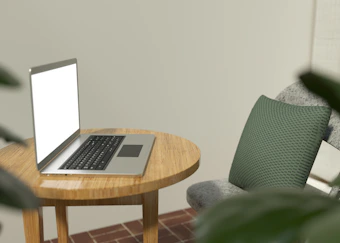 A minimalist workspace with earthy wood tones and a laptop displaying kludget's accommodation templates.