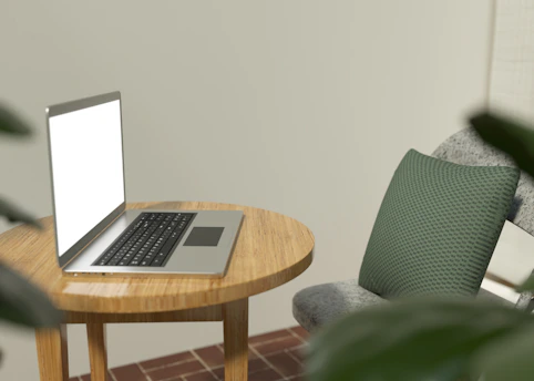 A calm, minimalist workspace with a laptop displaying a moving budget calculator on screen, surrounded by soft green and white decor.