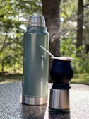 An outdoor scene featuring a person using a thermo tumbler.