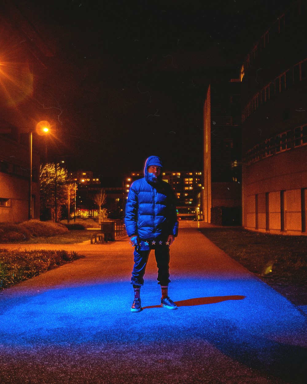 a man standing on a sidewalk at night