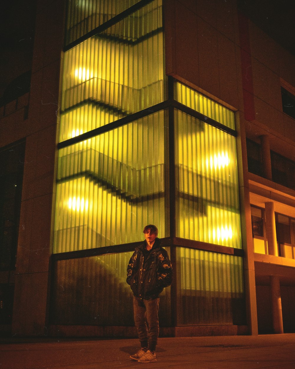 um homem em pé na frente de um edifício alto